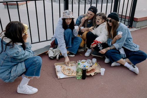 Group of Girls Eating on the Floor While Taking Photo