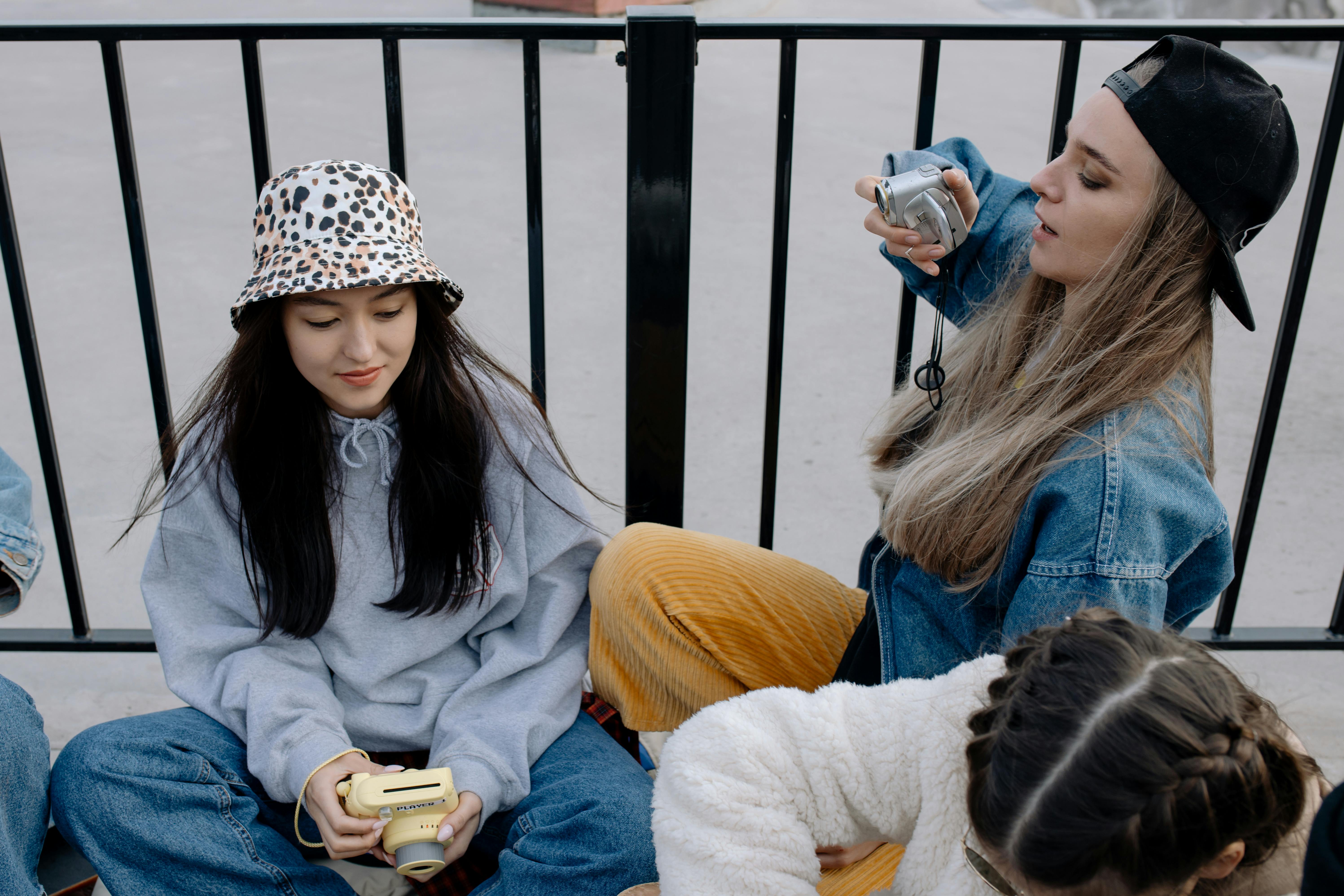 Group of young women with cameras enjoying a casual photography session outdoors.