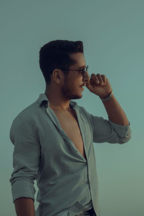 Free A young man in sunglasses poses casually outdoors, exuding style and confidence with a modern look. Stock Photo