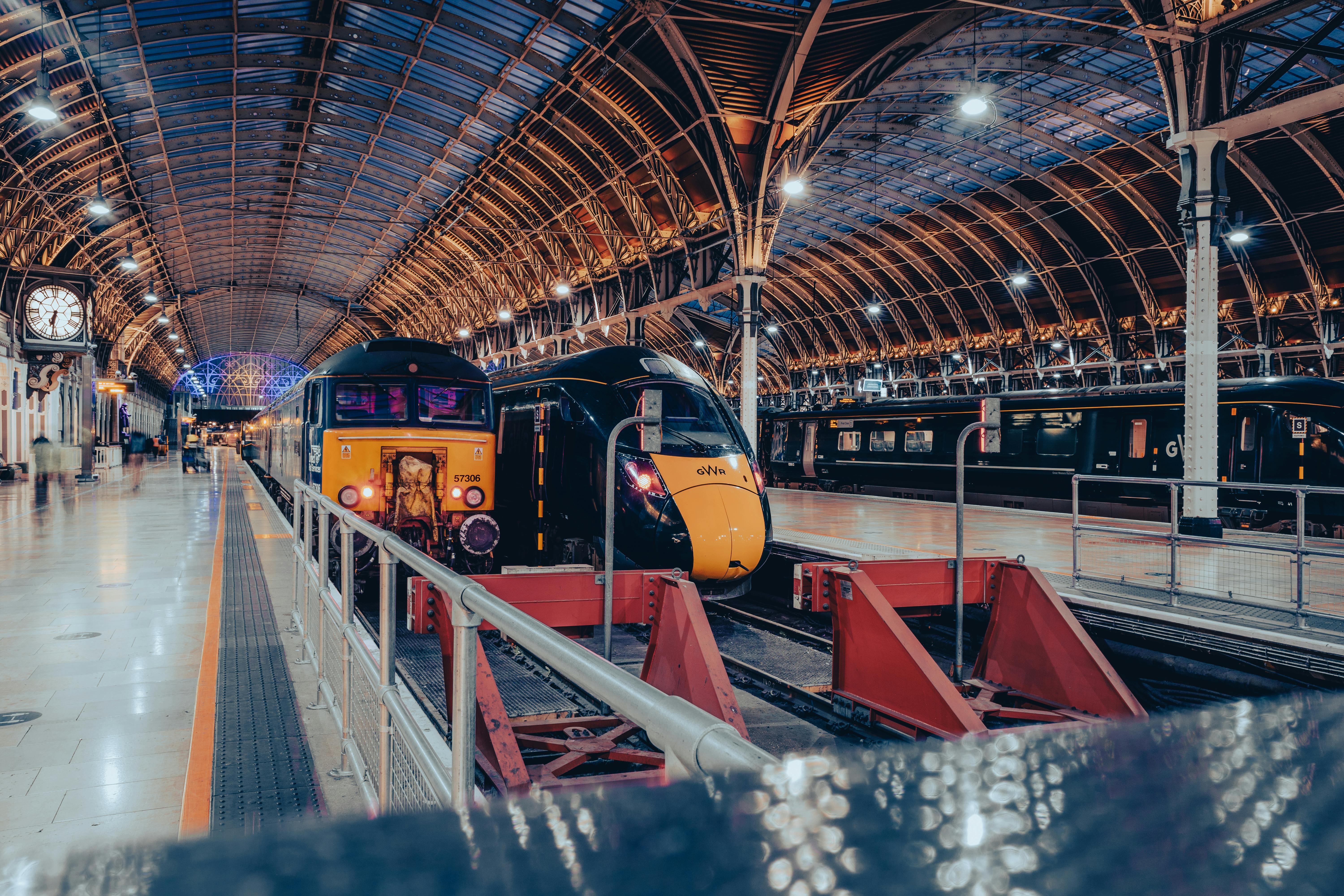London's Paddington Station showcasing modern trains under its iconic roof archway.