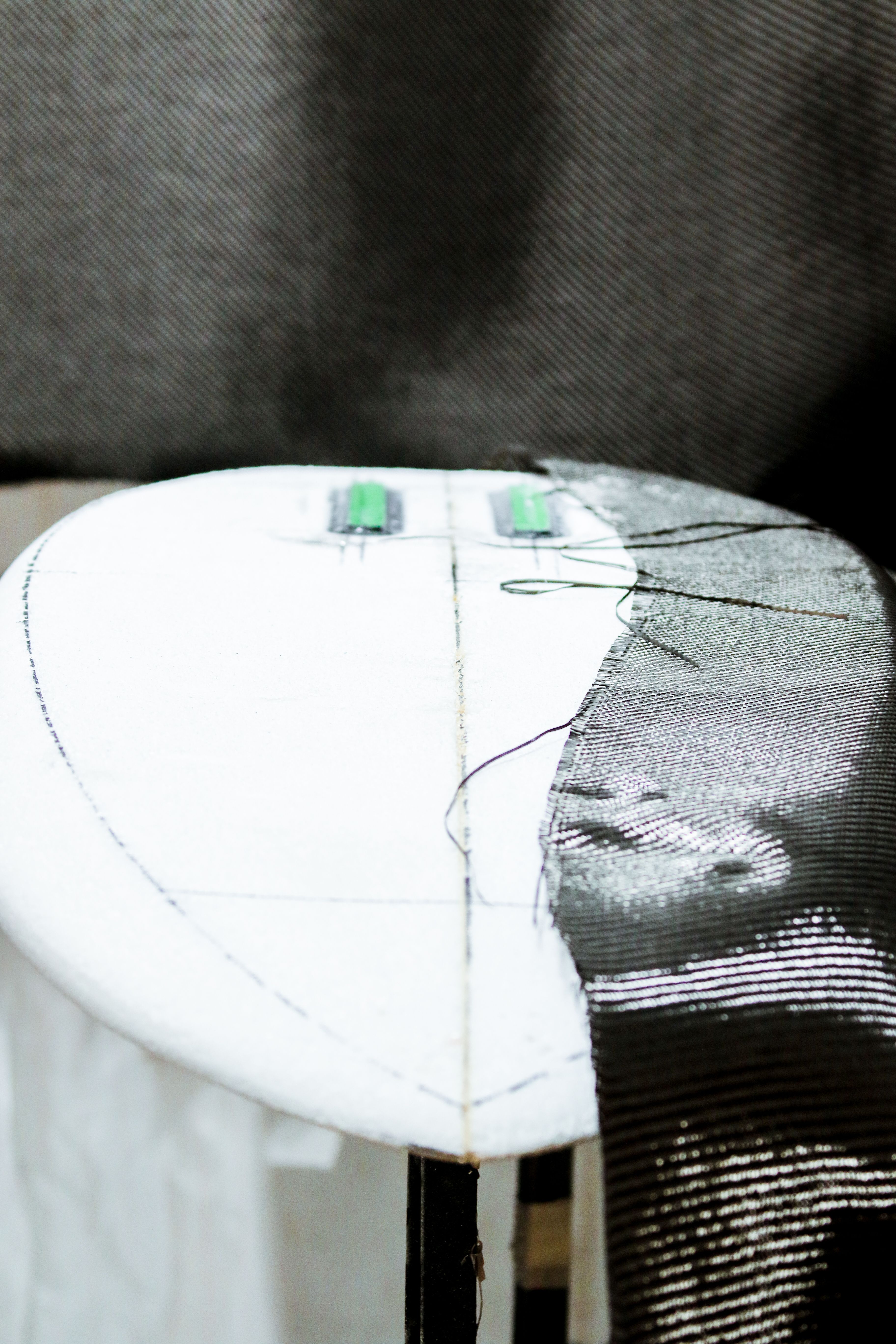 Fibreglass cloth laid over a surfboard blank, showing the materials side of the experimentation that changed modern surfcraft