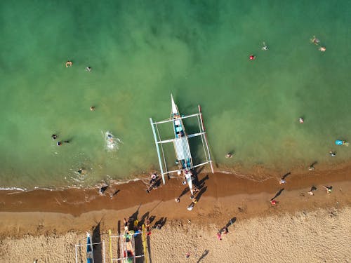 Free An Aerial Photography of People on the Beach Near the Boats Stock Photo