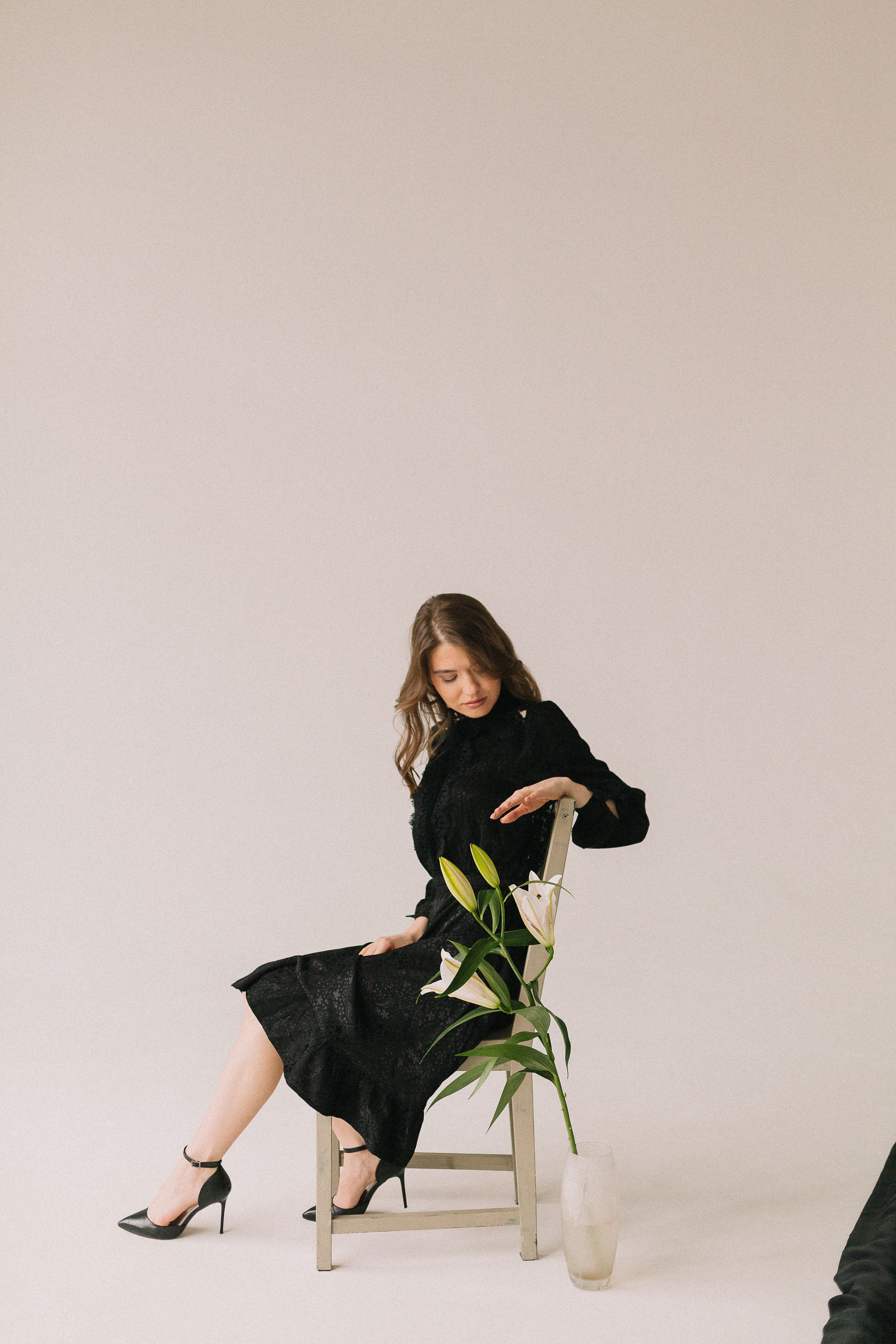 A Woman in a Black Dress Sitting on a Chair · Free Stock Photo
