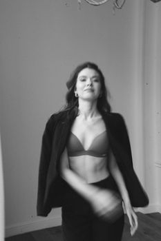 Black and white portrait of a woman posing with stylish fashion and a confident expression.