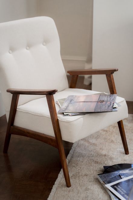 Cream armchair with a stack of magazines — photo by Ron Lach on Pexels