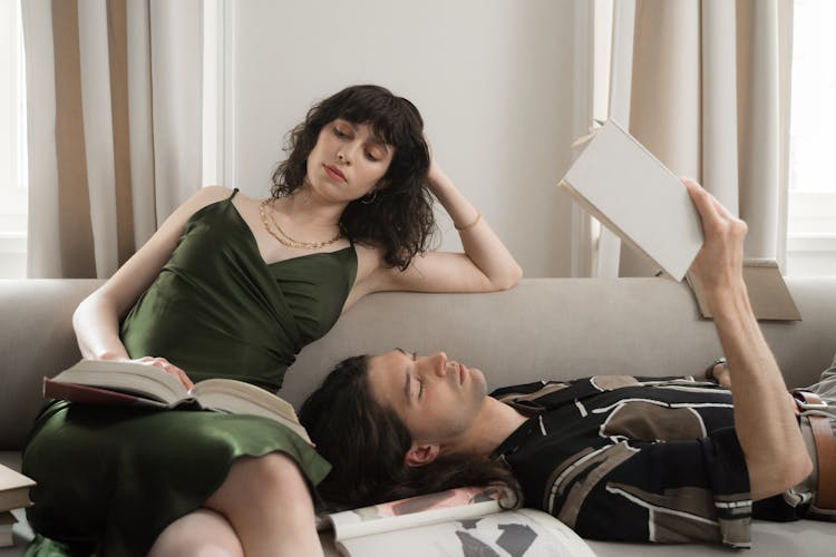 Man And Woman Reading Book On Bed