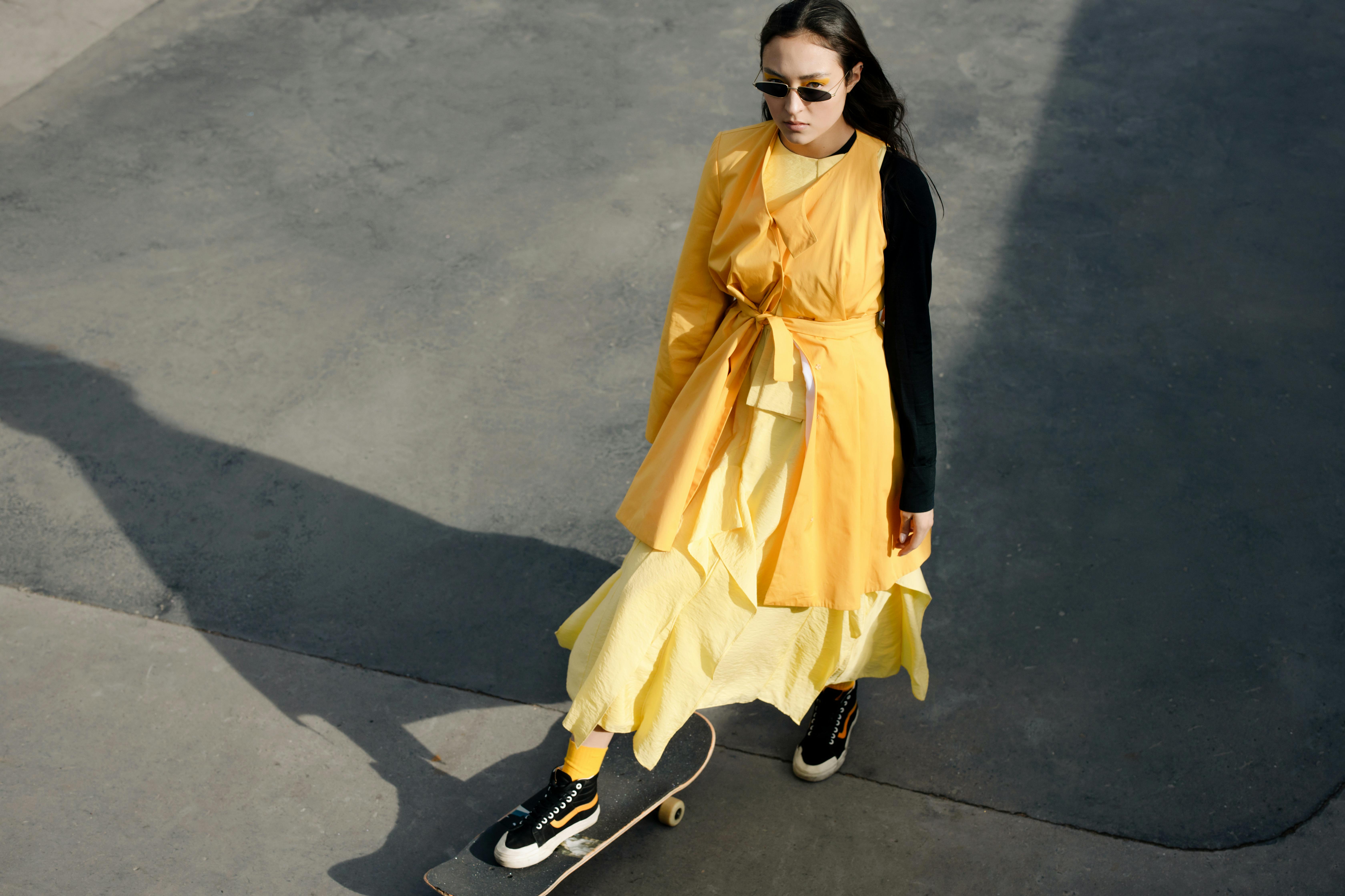 A Woman In Yellow Dress Skateboarding · Free Stock Photo