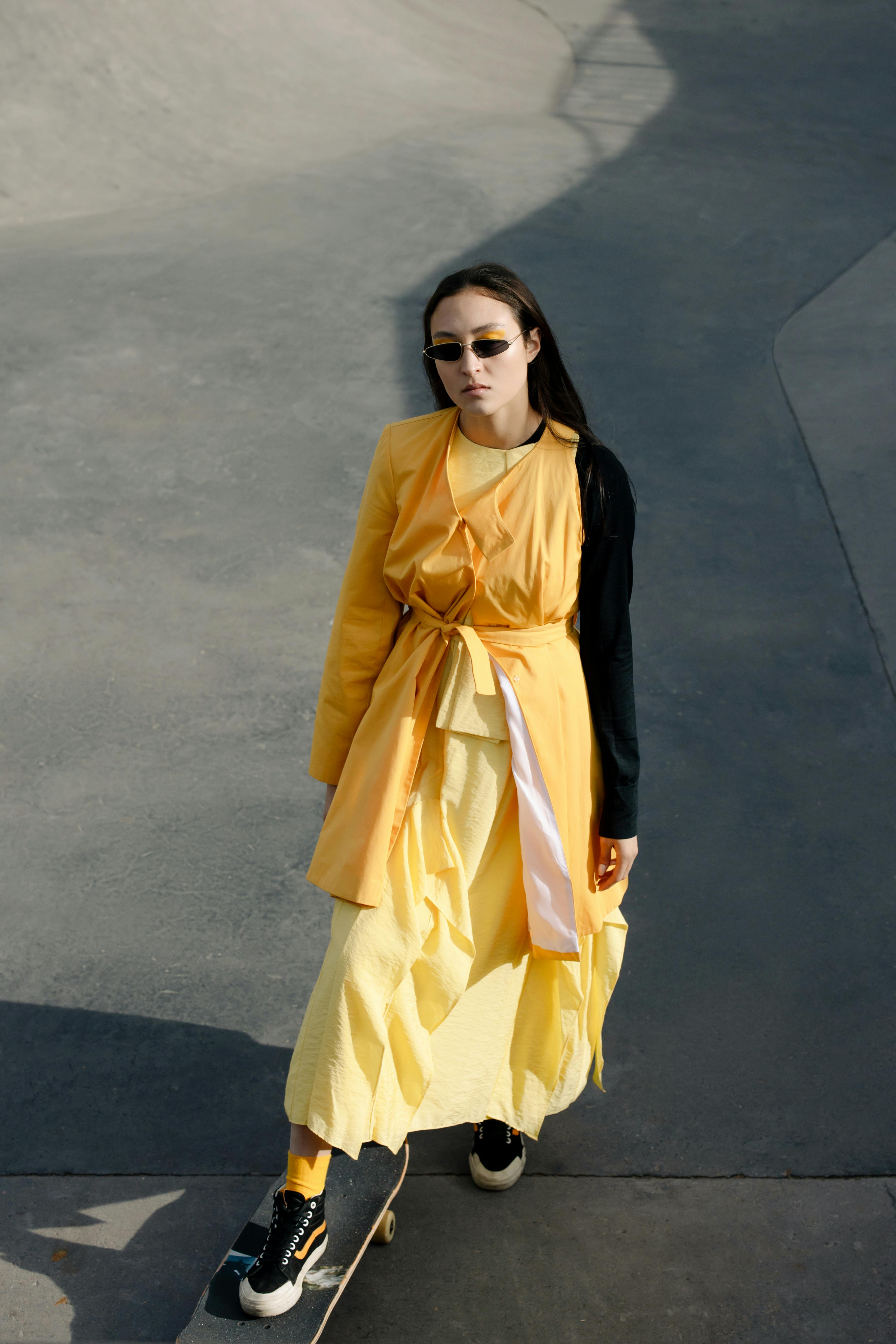 A Fashionable Woman in Yellow Dress Skateboarding · Free Stock Photo