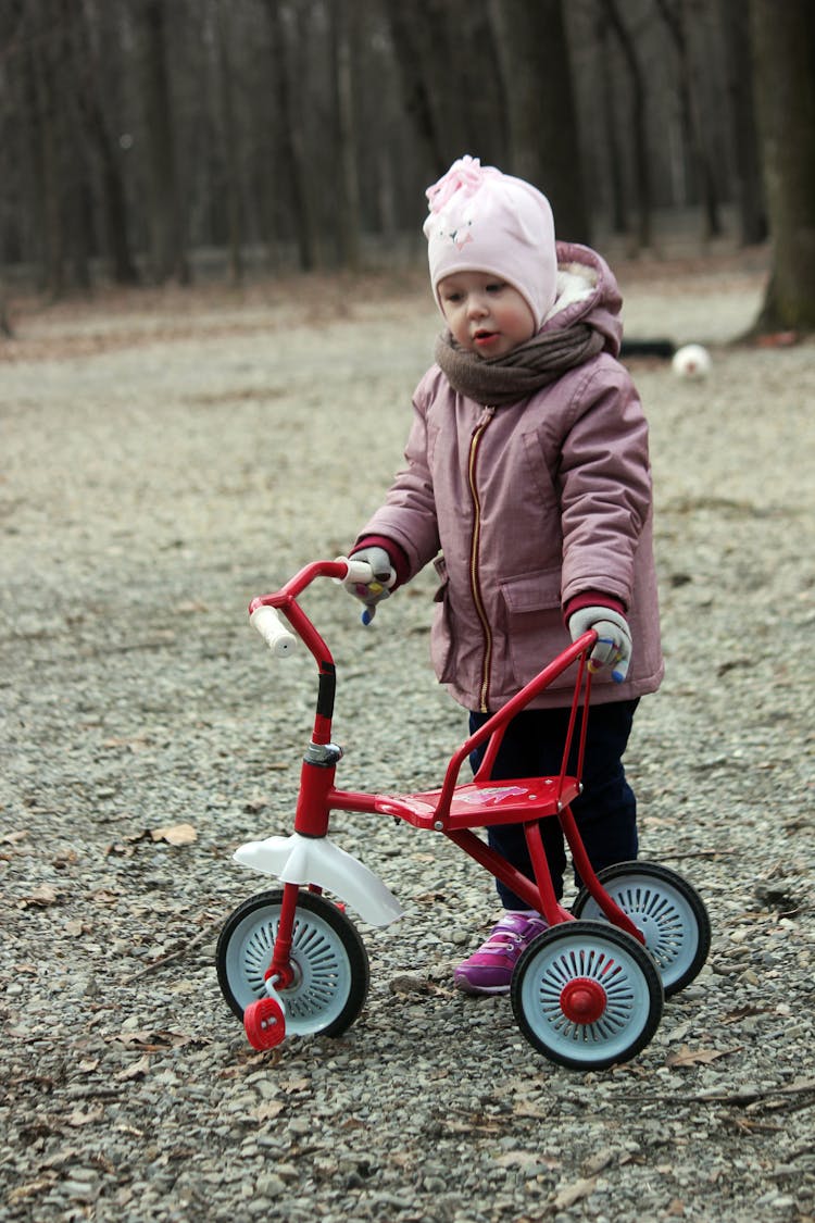 Baby Girl Playing With Bicycle In Yard