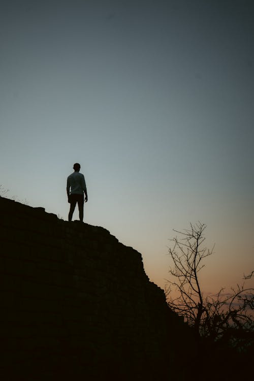 Free Man Standing on Rock Formation Stock Photo
