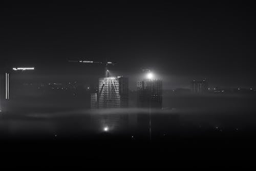 Illuminated Cranes on High Rise Buildings during Construction 