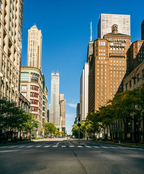 Free Street-level view of Chicago skyline, showcasing skyscrapers and urban architecture under a bright blue sky. Stock Photo
