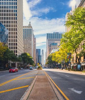 Dynamic city street view with skyscrapers, vibrant sky, and bustling traffic.