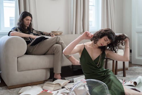 Man Reading Book and Woman Listening to Music