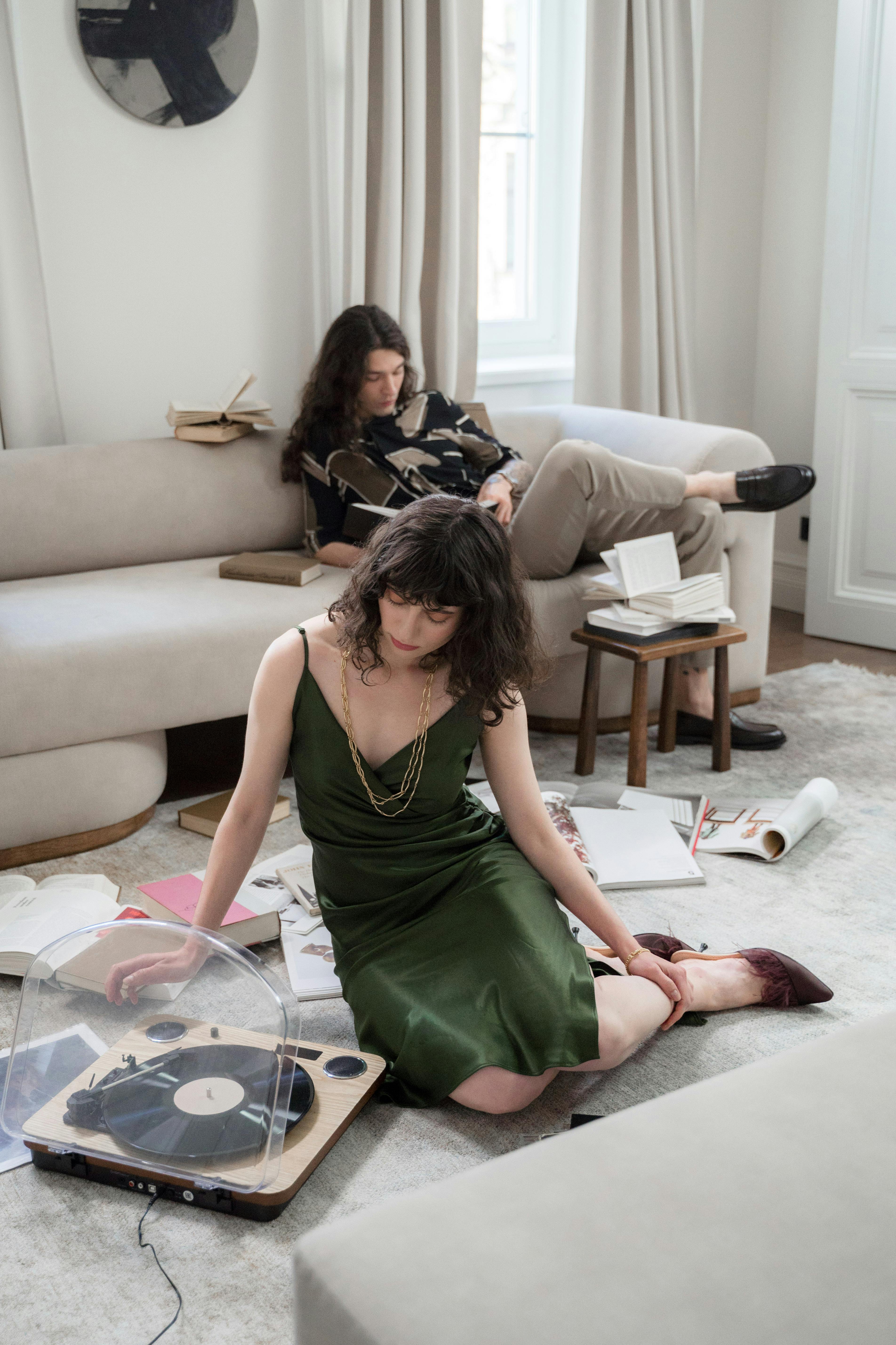 woman on floor with vinyl recorder and man on bed