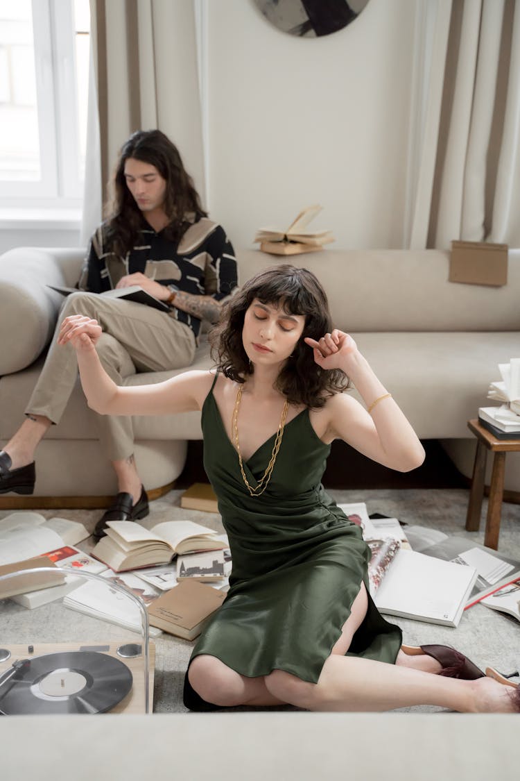 Woman Dancing On Floor And Man Reading Book On Bed