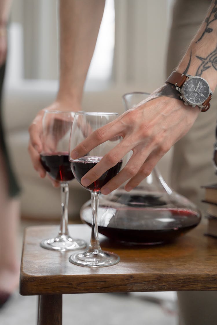 Close Up On Man Putting Wine Glasses On Table