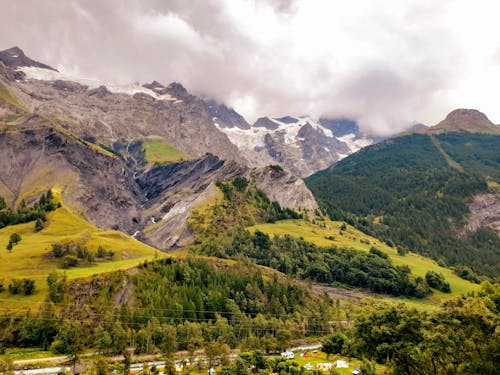 An Aerial Photography of Green trees on Mountain Under the Cloudy Sky