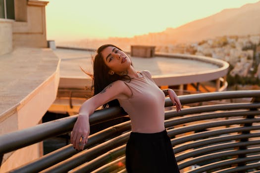 A woman enjoying a serene moment on a balcony at sunset, capturing the city's beauty.
