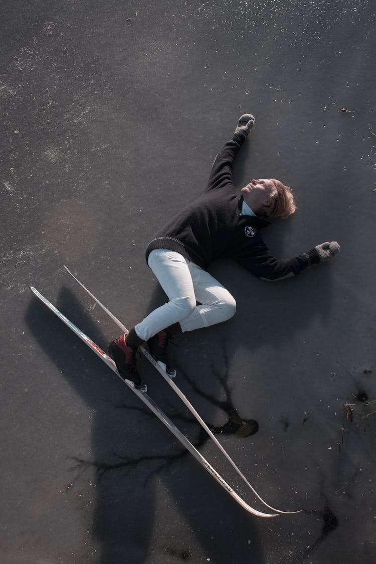 A Person With Skis Lying On Ice