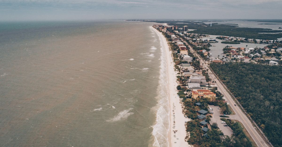 A stunning aerial view of a coastal seaside town showcasing beaches, buildings, and the ocean.