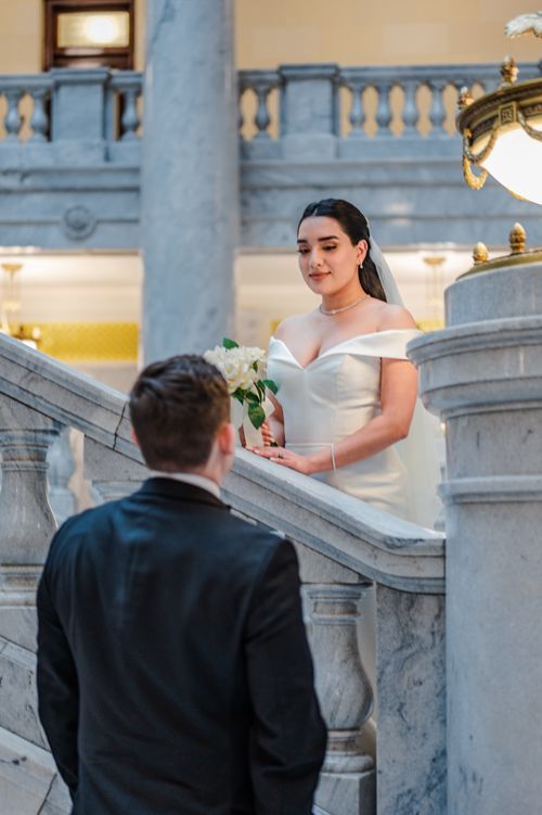 Free Bride and groom share a tender moment on a grand marble staircase. Stock Photo