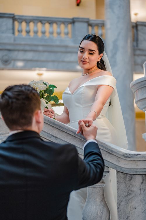 Free Bride and groom holding hands on a grand staircase during a wedding ceremony. Stock Photo
