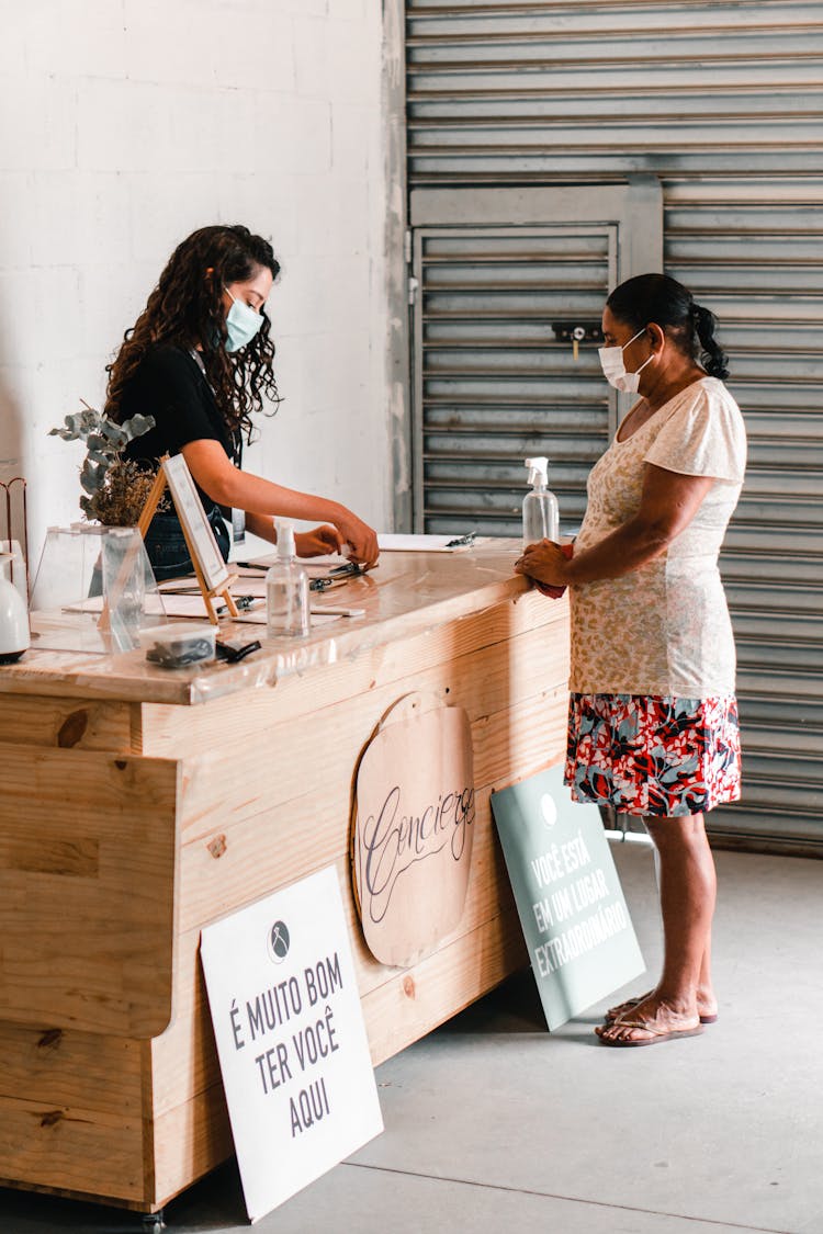 A Woman Standing Behind A Counter