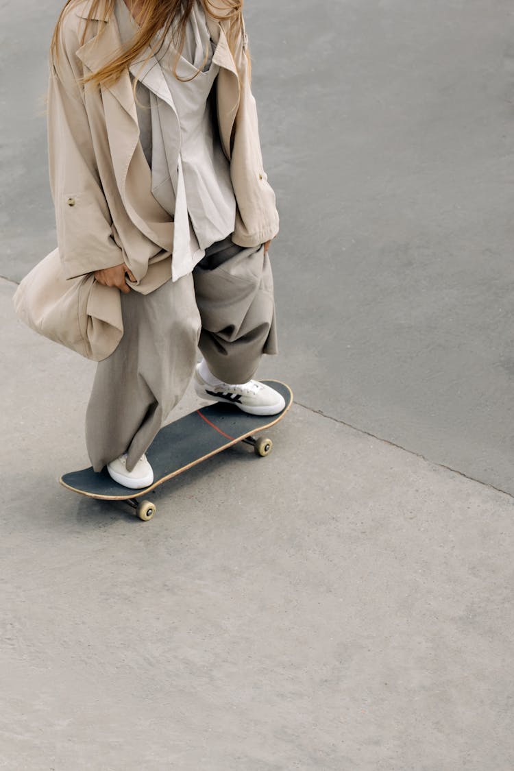 A Person Wearing Loose Clothing Riding A Skateboard