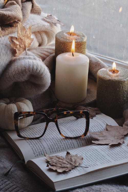 Eyeglasses Beside Pillar Candles