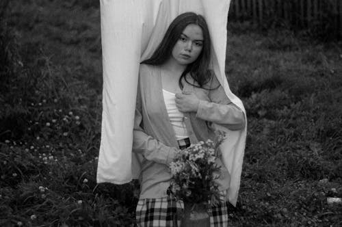 A Grayscale Photo of a Woman Holding Flowers
