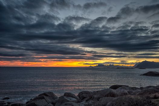 Dramatic sunset with clouds over the Nordland coastline, Norway.