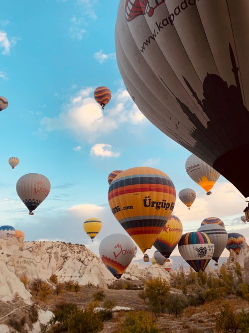 Free Stunning view of colorful hot air balloons floating over Cappadocia's unique landscape at sunrise. Stock Photo