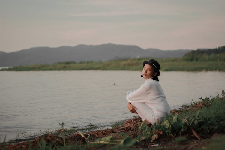 Beautiful Woman Crouching Near Lake