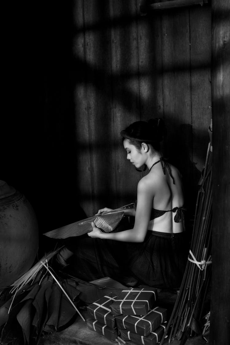 Woman Sitting With Boxes In Black And White