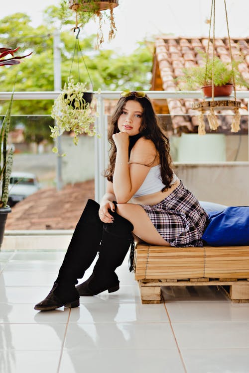 A Woman in White Tank Top and Plaid Skirt