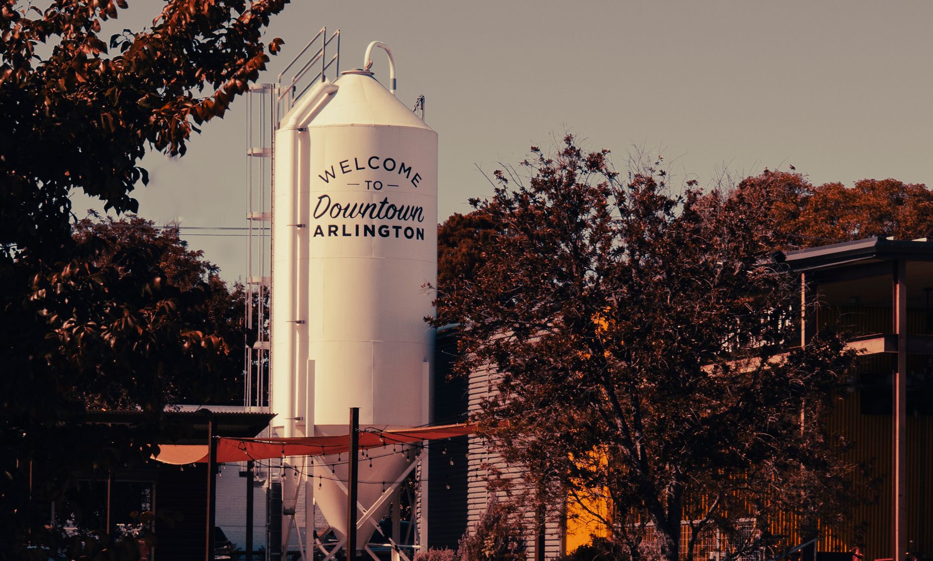 Industrial scene in Arlington, Texas featuring a prominent silo and surrounding autumn foliage.