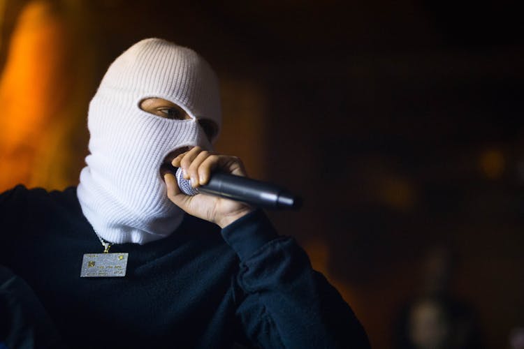 Masked Man Singing To Microphone