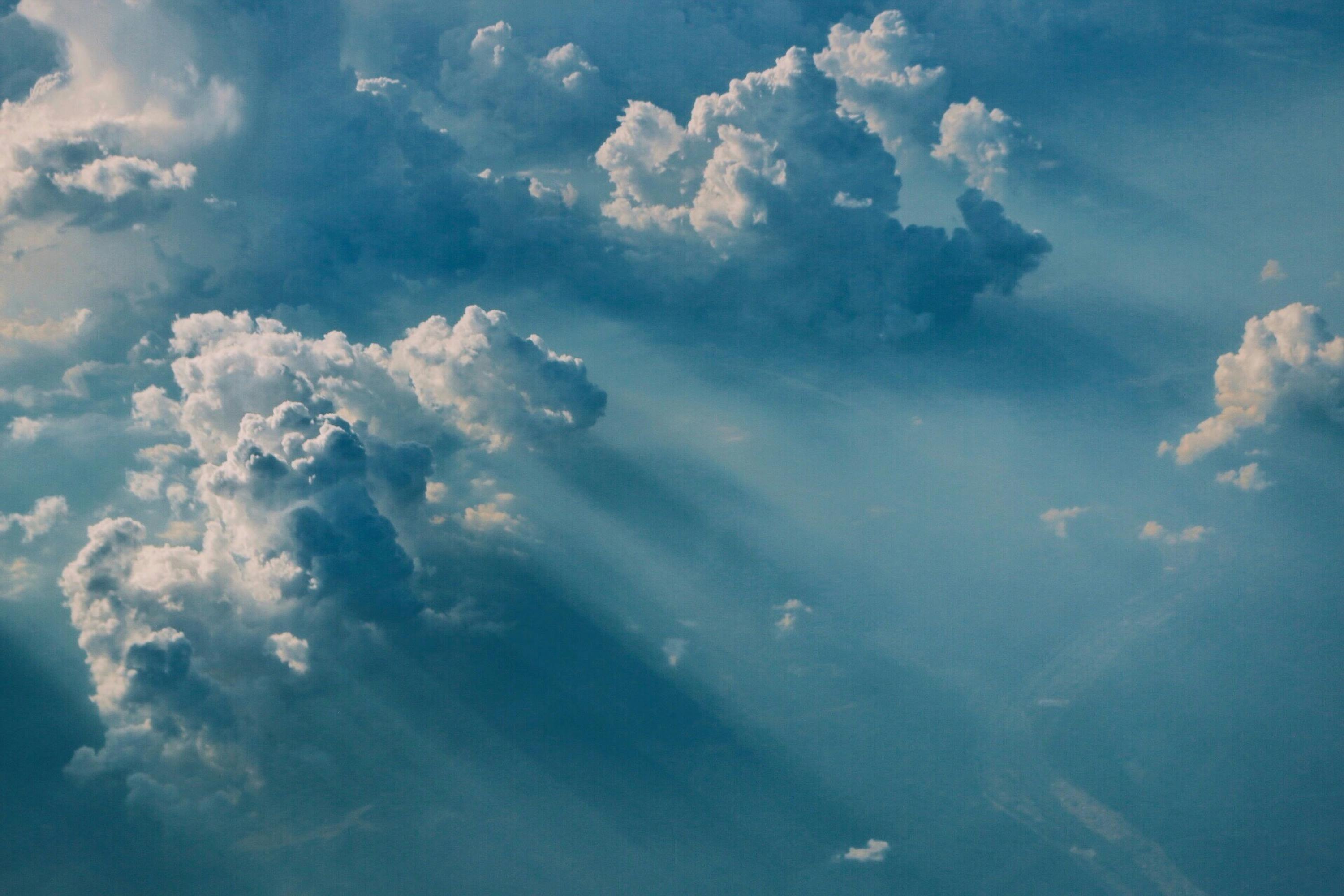 Aerial view of clouds with sunlight streaming through, creating a heavenly atmosphere.
