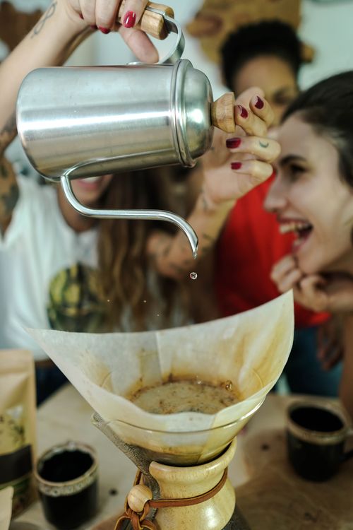 Free Friends enjoying the process of brewing coffee using a pour-over method. Stock Photo