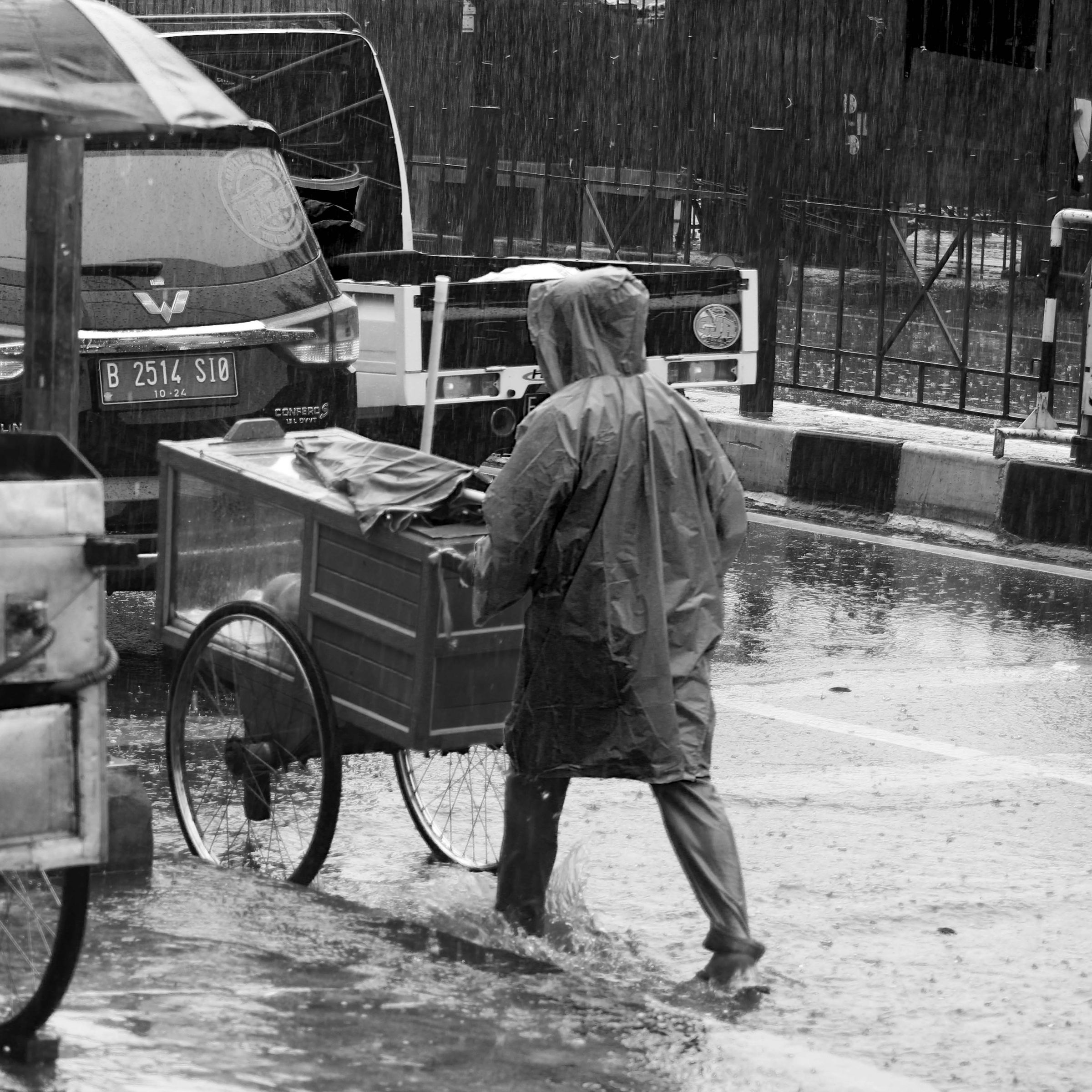Person walking through city rain in a waterproof raincoat