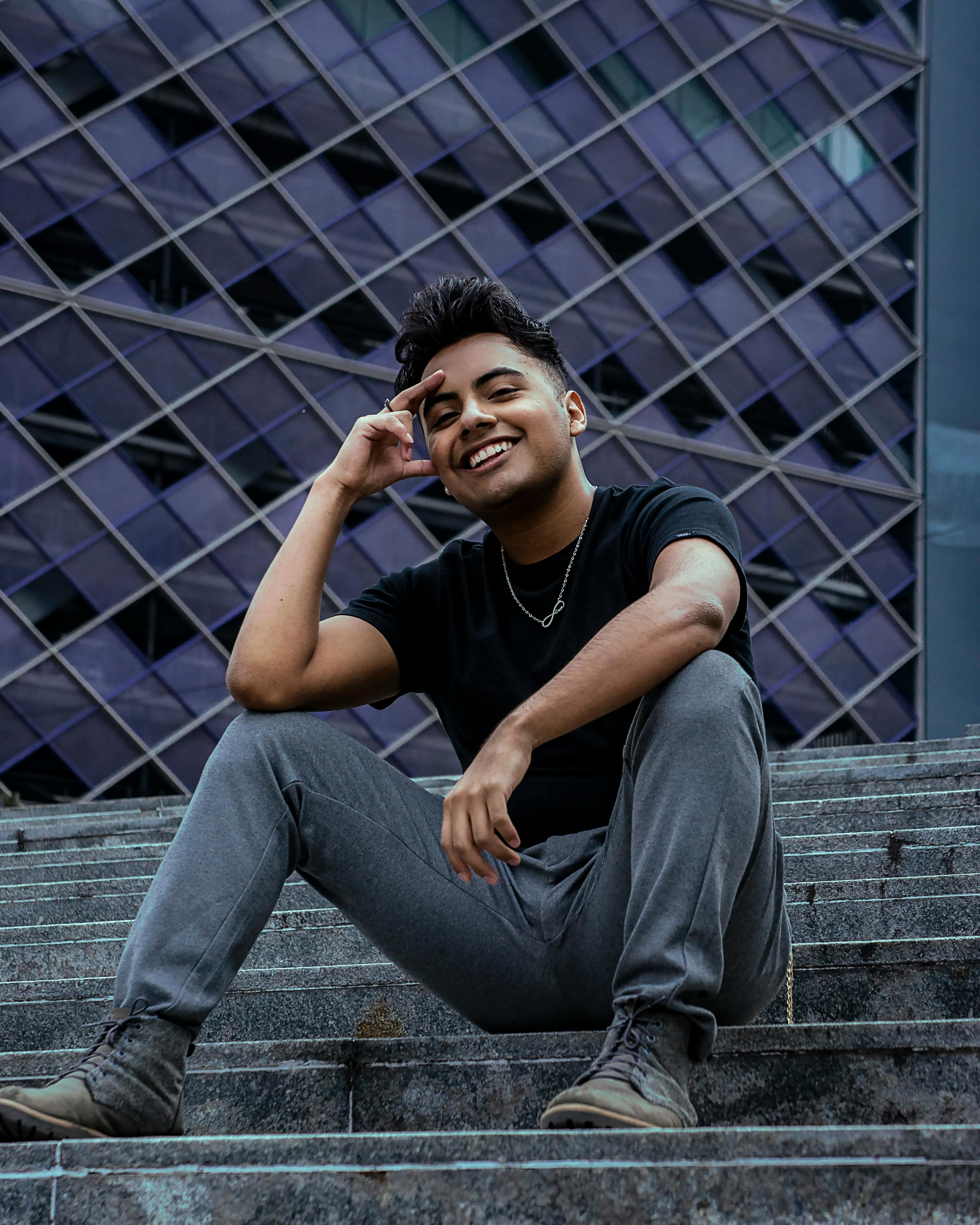 Man in Black Crew Neck T-shirt and Black Pants Sitting on Gray Concrete  Stairs · Free Stock Photo