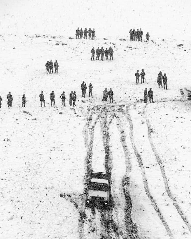 Vehicle And People On A Snow Covered Landscape