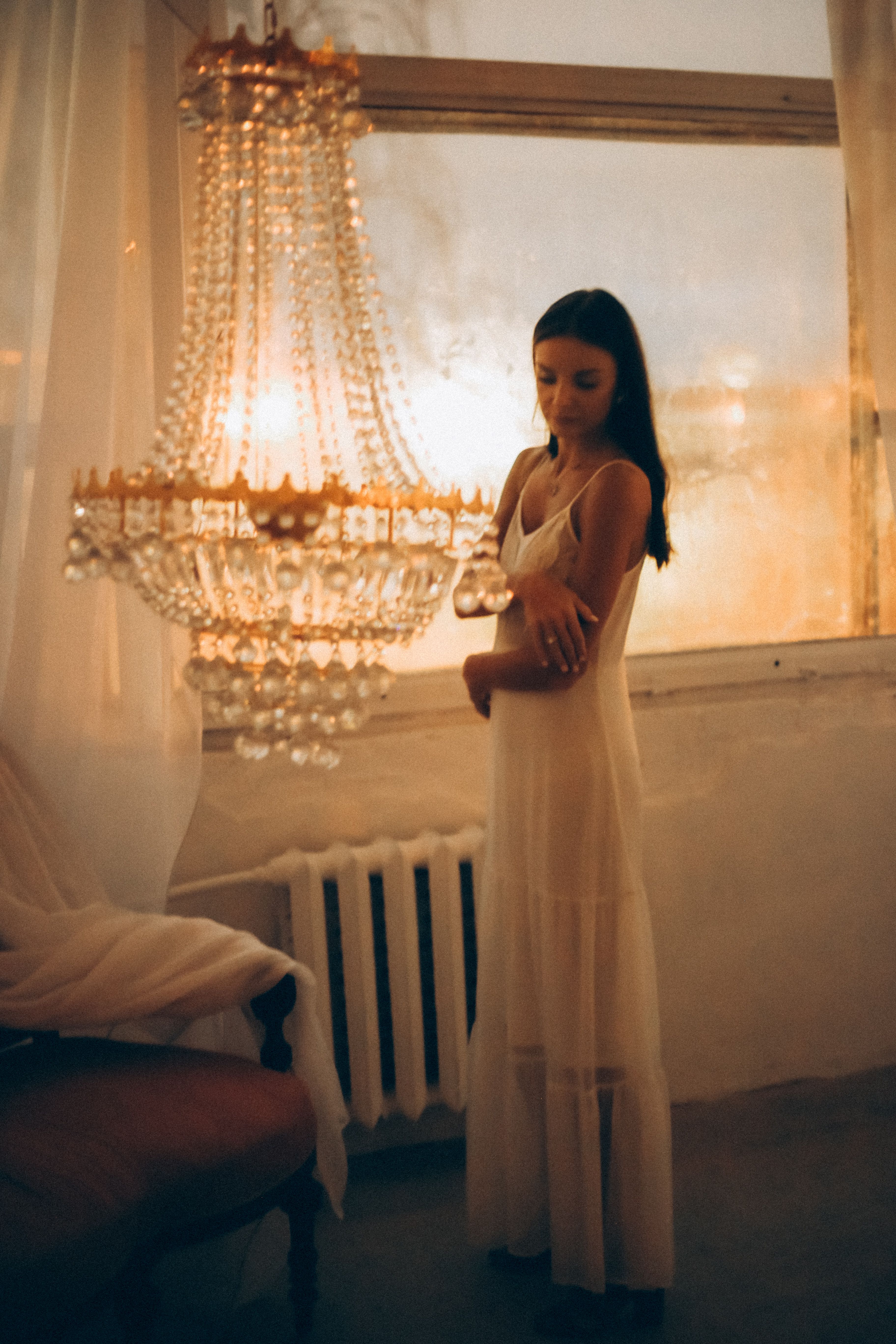 Woman in White Dress Standing Near a Chandelier · Free Stock Photo