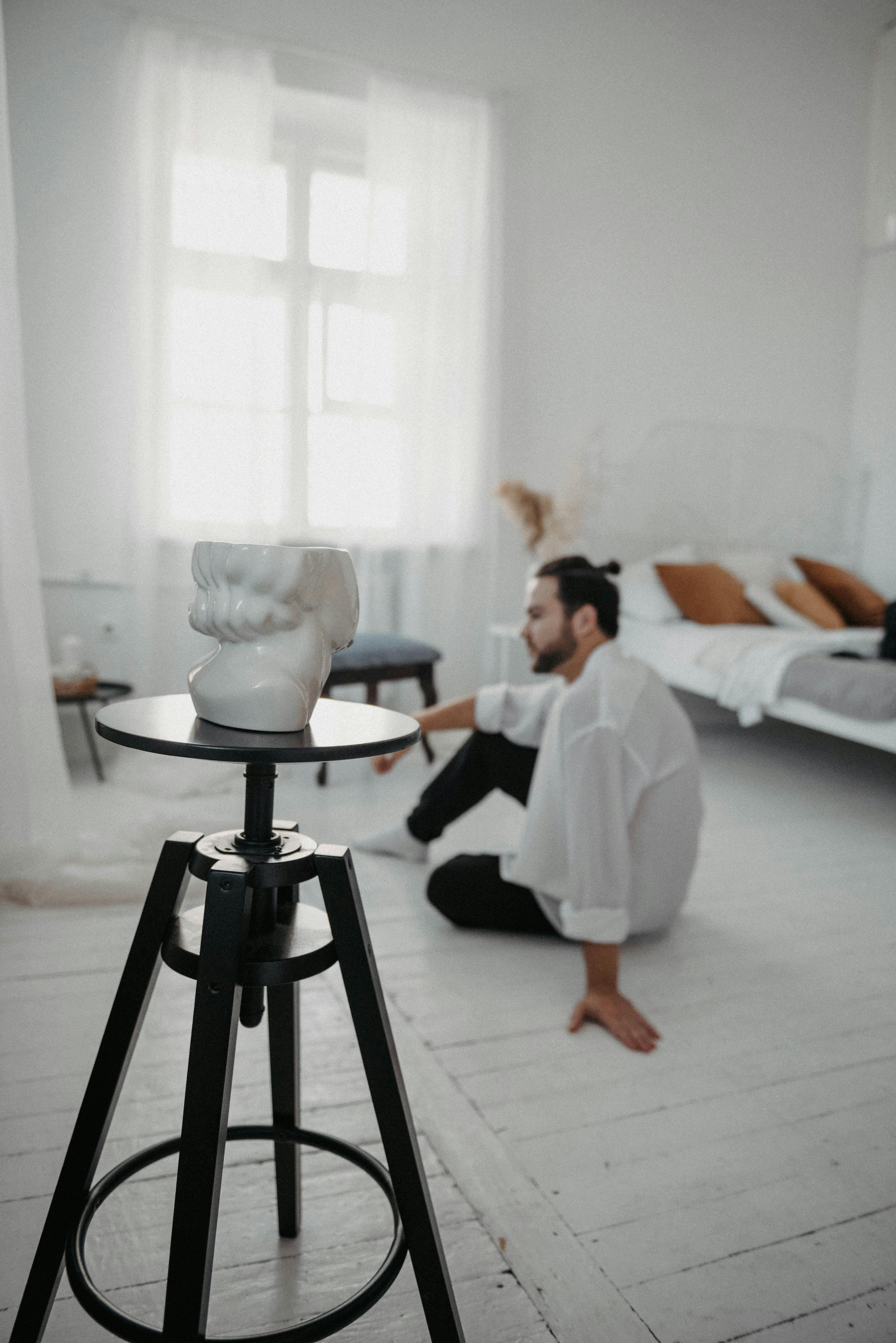 Sculpture on Table and Man Sitting on Floor · Free Stock Photo