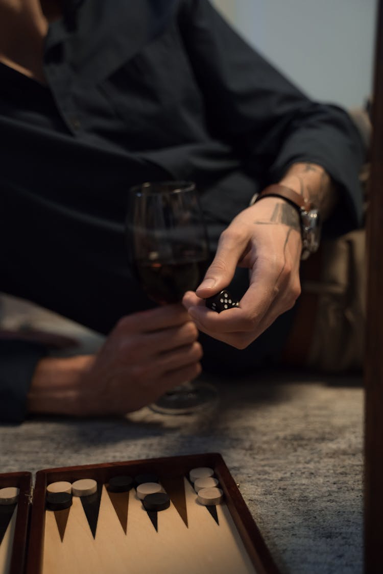 Unrecognizable Male Hands Holding Glass Of Wine And Playing Backgammon