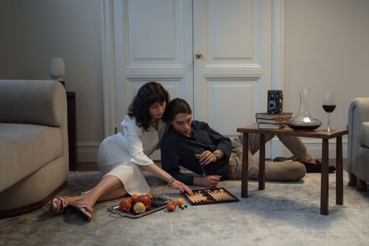 Couple Sitting on Floor Playing Backgammon