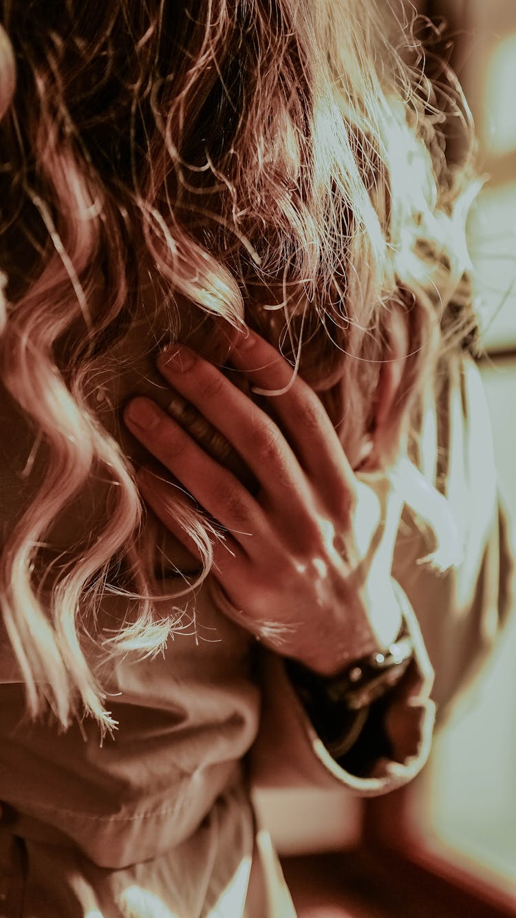 Hand Of A Woman Touching Curly Hair