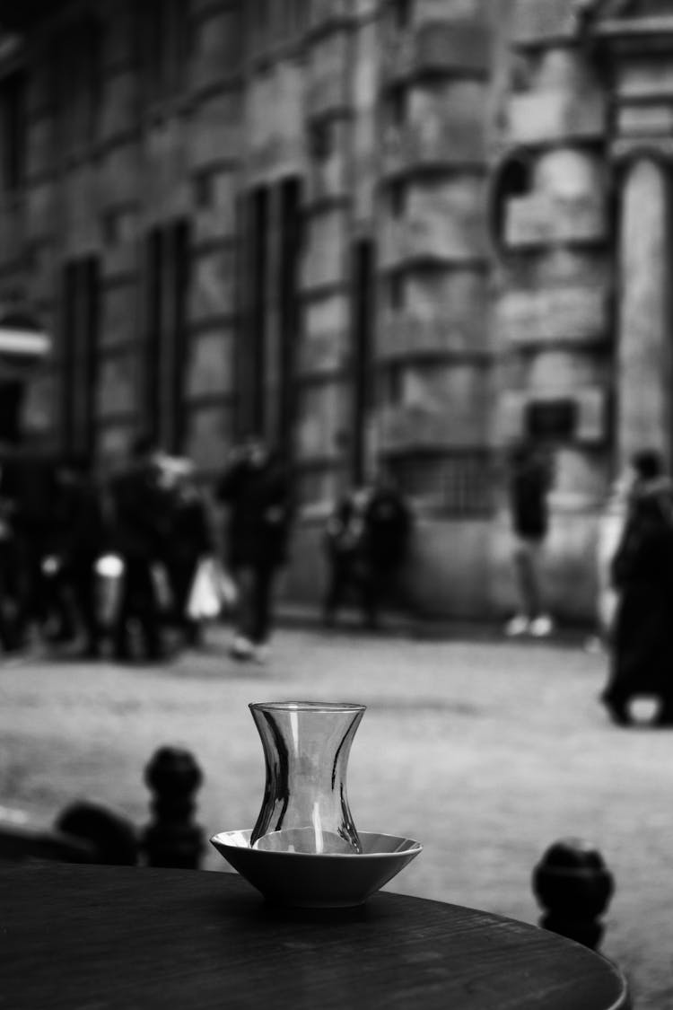 Vase Of Glass And Ceramic Bowl On Round Table With Vintage Photo In Background