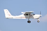 A White Biplane Flying in the Sky